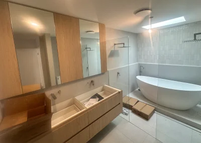 Timber vanity, large mirror and freestanding bath during bathroom renovation at Palm Beach