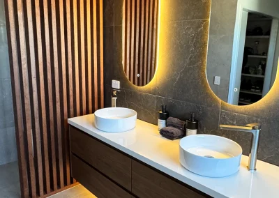 Close-up of timber vanity with vessel basin, underlit benchtop and timber battens at Palm Beach