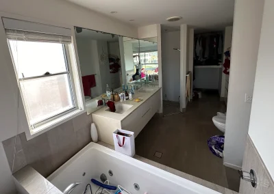 Outdated bathroom with spa bath, mirrored wall and old fixtures before renovation at Palm Beach