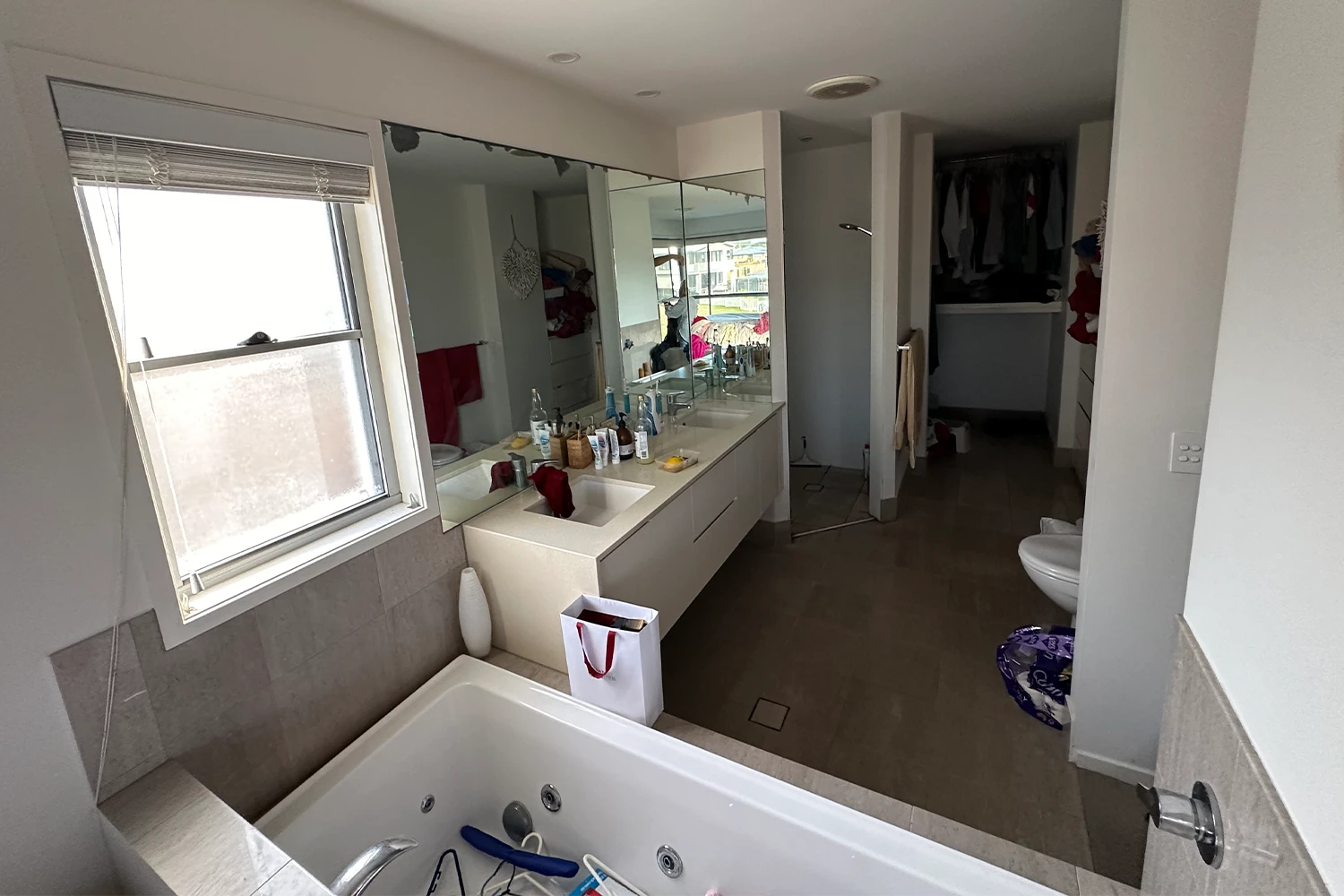 Outdated bathroom with spa bath, mirrored wall and old fixtures before renovation at Palm Beach