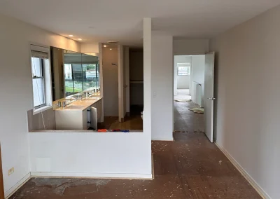 Hallway and bathroom entry with dated finishes before renovation at Palm Beach