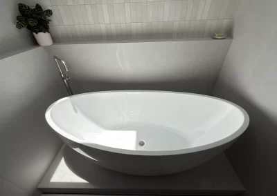 Freestanding oval bathtub and grey large-format tiles in a finished Barracuda Avenue bathroom