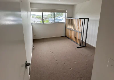 Bedroom with worn carpet and timber railing before renovation at Palm Beach