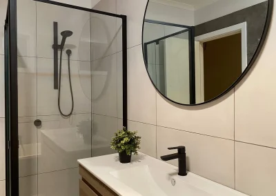 Renovated bathroom with new shower and tiling at Fifth Avenue Palm Beach