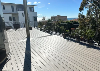 Finished composite deck with potted plants, metal railing and ocean views in Currumbin